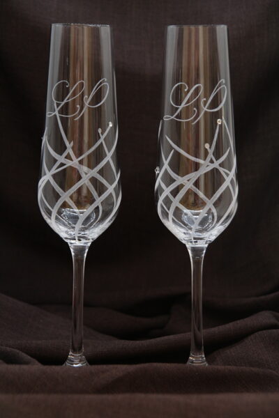 Vēja stiebri. Gravētas šampanieša glāzes. Pāris.